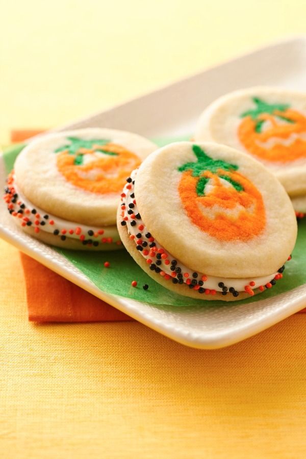 Frosting and sprinkles sandwiched between pumpkin shaped sugar cookies! This is an easy Halloween treat for the kids!